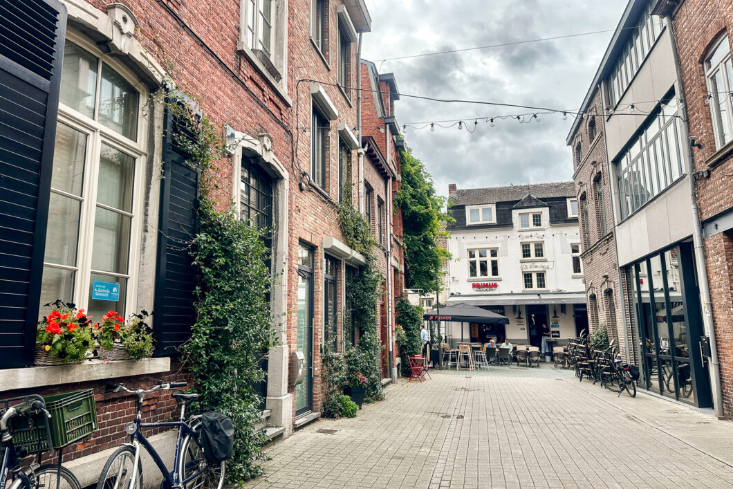 Het cafestraatje Hemelrijk in Hasselt met geraniums voor de ramen en fietsen tegen de gevel